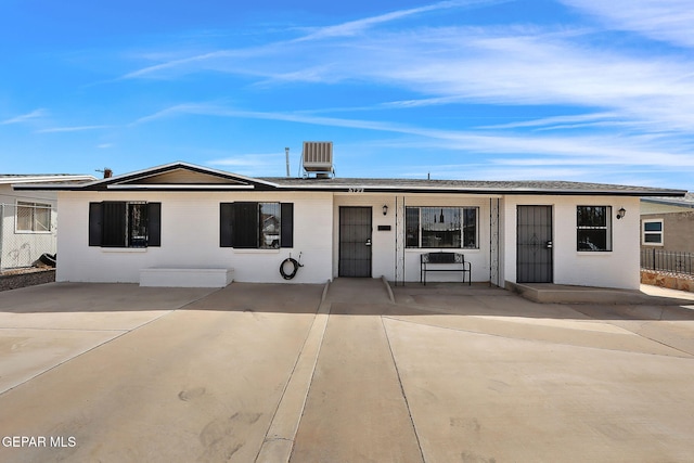 view of front of property with central AC unit, a patio, and fence