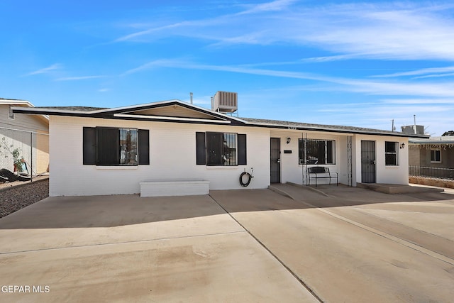 ranch-style home with cooling unit and a patio area