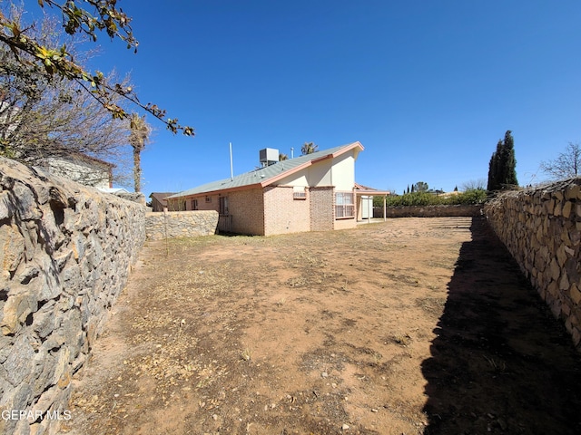 view of yard with central air condition unit and fence