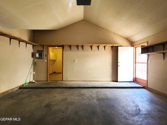 garage featuring electric panel and baseboards