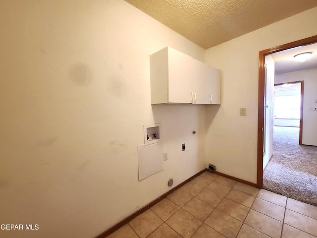 clothes washing area with washer hookup, hookup for a gas dryer, cabinet space, electric dryer hookup, and a textured ceiling