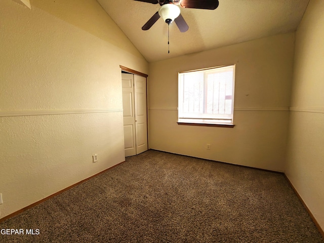 unfurnished bedroom featuring lofted ceiling, baseboards, a closet, and carpet floors