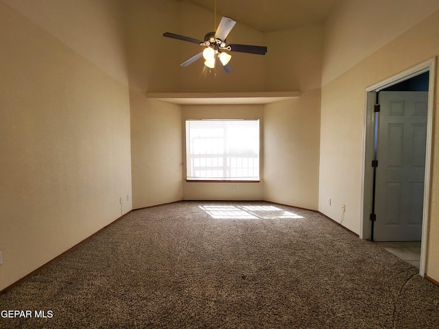 spare room with carpet floors, a high ceiling, and a ceiling fan