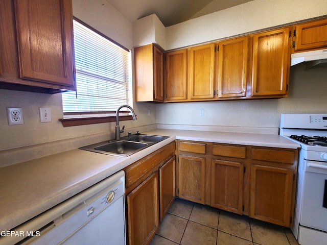 kitchen with a sink, white appliances, under cabinet range hood, and light countertops