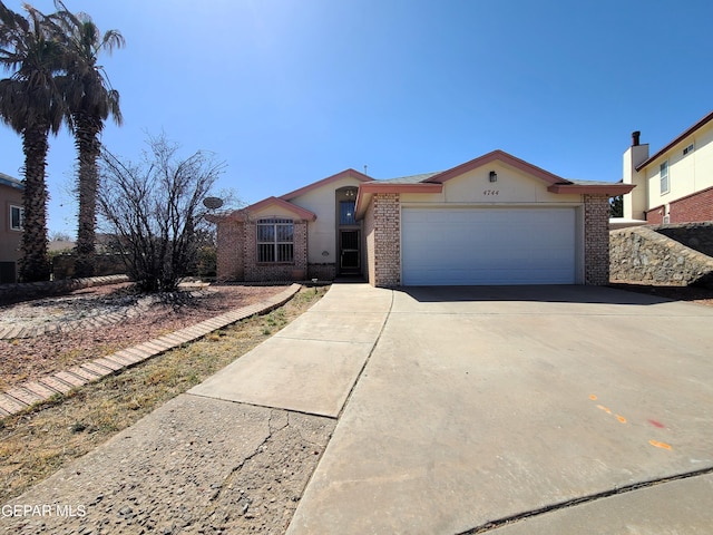 ranch-style house featuring brick siding, driveway, and an attached garage