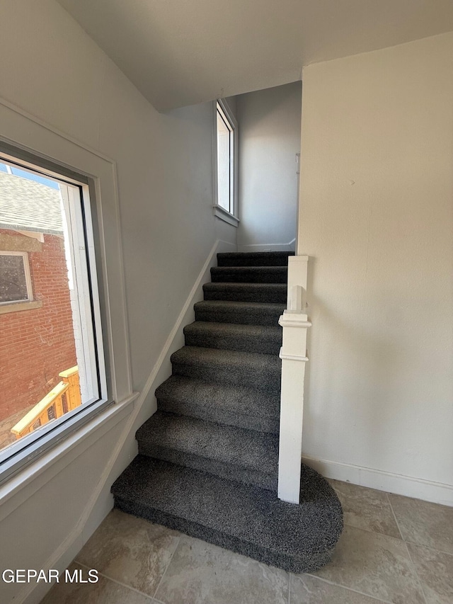 staircase featuring a wealth of natural light and baseboards