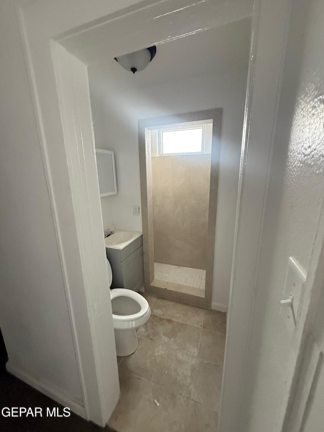 full bath featuring tile patterned floors, toilet, and a tile shower