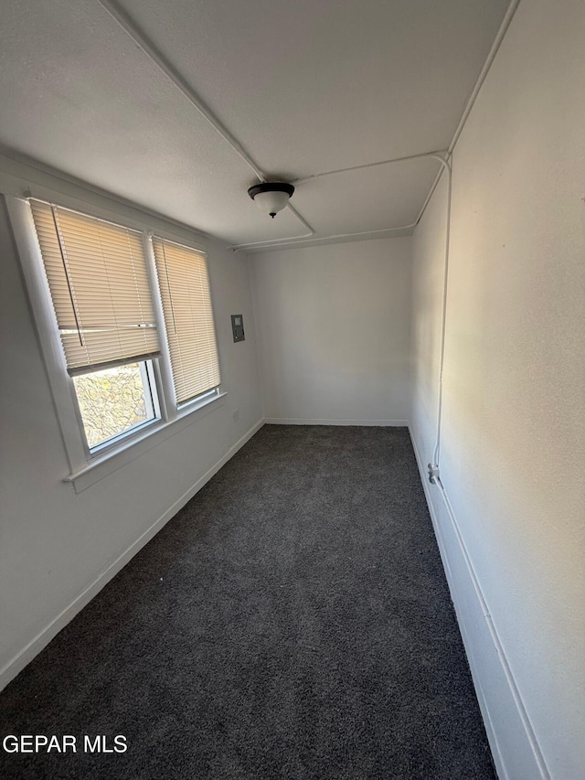 empty room featuring baseboards and carpet