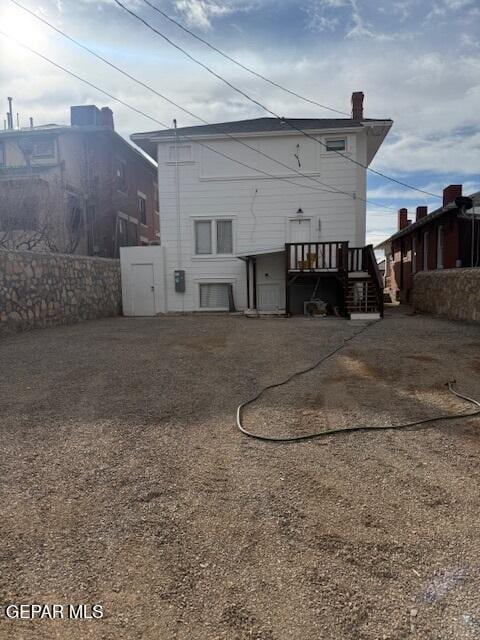 back of property featuring a chimney and fence