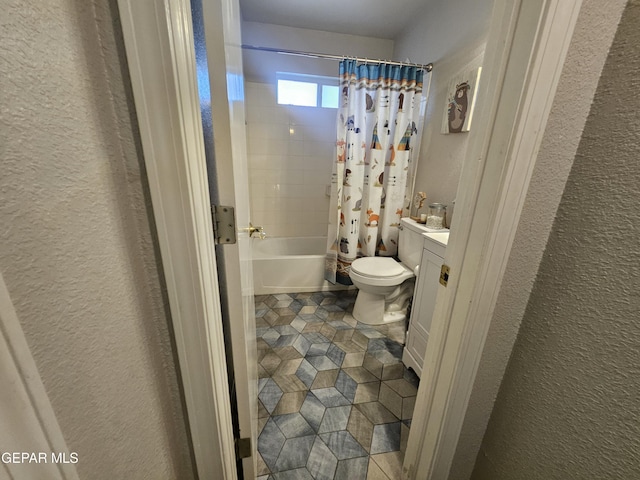 bathroom with vanity, toilet, a textured wall, and shower / tub combo with curtain