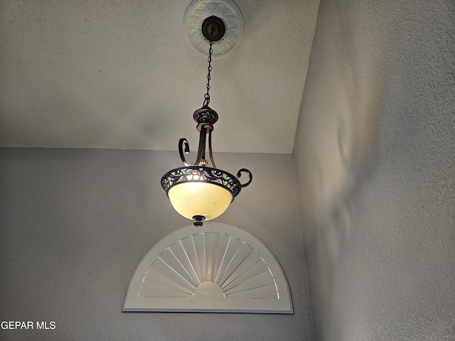 details featuring a textured ceiling and a textured wall