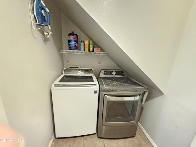 washroom with baseboards, independent washer and dryer, and laundry area