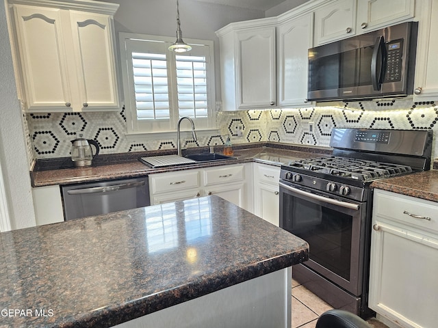 kitchen with tasteful backsplash, light tile patterned flooring, white cabinets, stainless steel appliances, and a sink