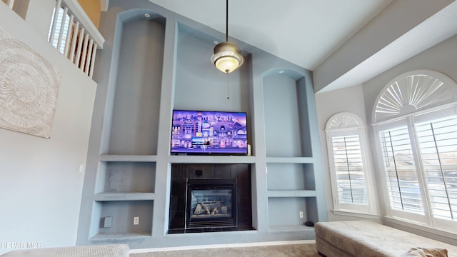 carpeted living area featuring built in shelves and a glass covered fireplace