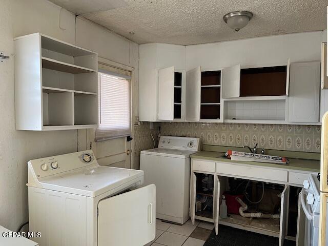 laundry room with laundry area, washing machine and dryer, and a textured ceiling