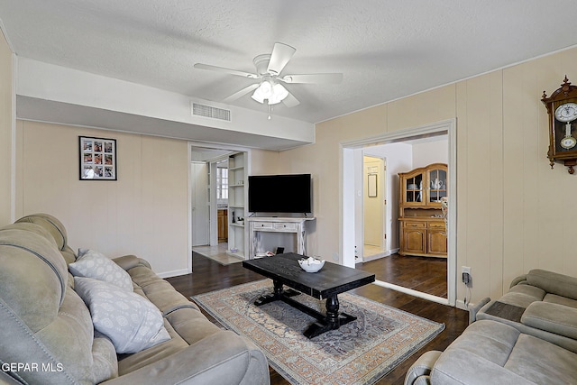 living area featuring dark wood finished floors, a textured ceiling, and ceiling fan