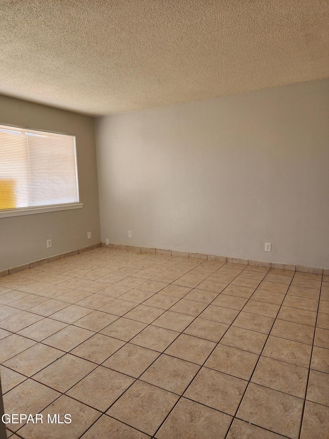 unfurnished room featuring light tile patterned floors and a textured ceiling