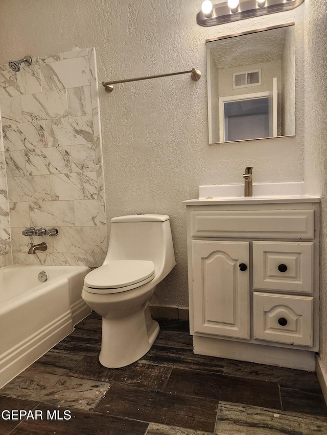 full bathroom with visible vents, toilet, a textured wall, shower / bathing tub combination, and wood finished floors