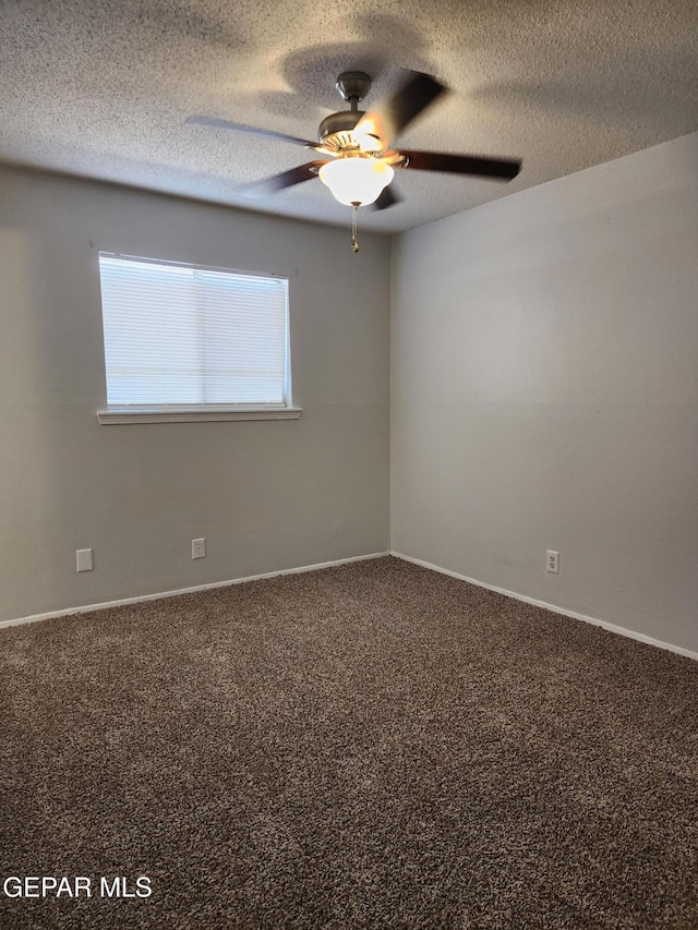 unfurnished room featuring baseboards, ceiling fan, a textured ceiling, and carpet