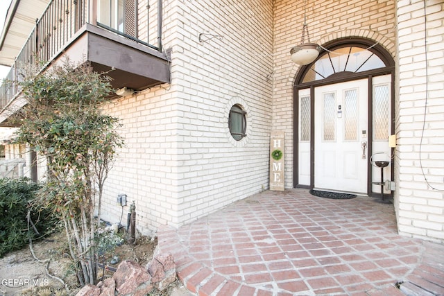 entrance to property featuring brick siding