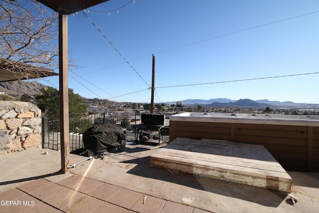 view of patio / terrace featuring a mountain view and a hot tub