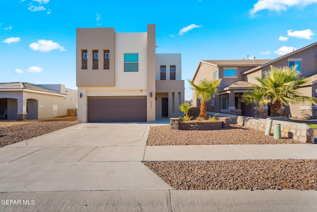 view of front of house featuring a garage, driveway, and stucco siding