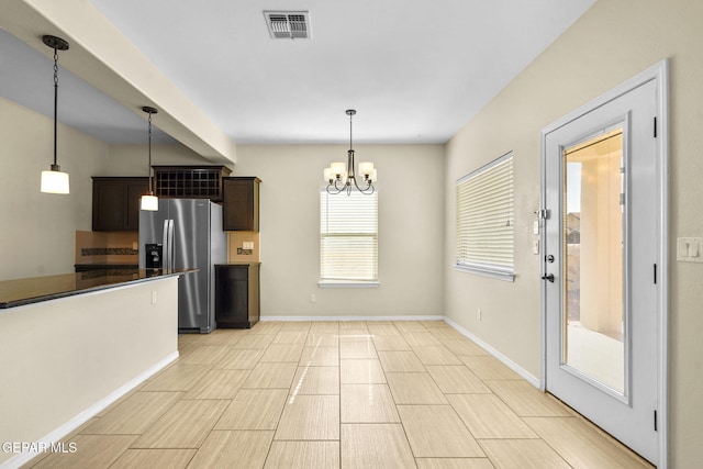 kitchen with visible vents, dark brown cabinetry, decorative light fixtures, an inviting chandelier, and stainless steel refrigerator with ice dispenser