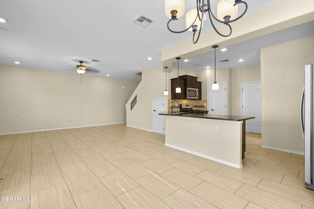 kitchen with visible vents, dark brown cabinets, ceiling fan with notable chandelier, appliances with stainless steel finishes, and a sink