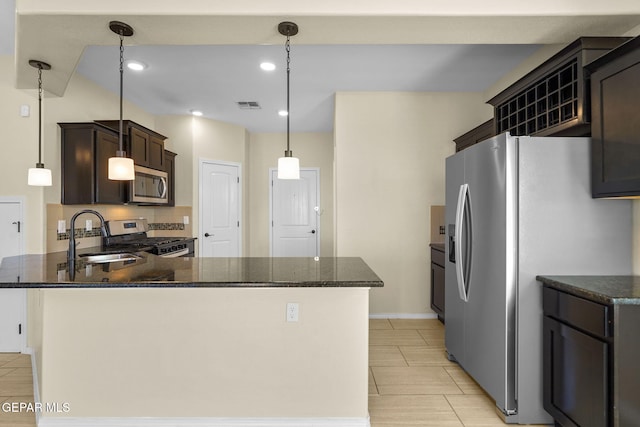 kitchen with visible vents, a sink, appliances with stainless steel finishes, a peninsula, and dark brown cabinets