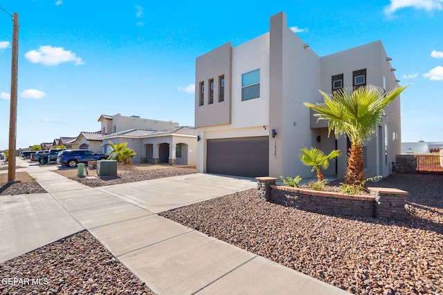 view of front of home with stucco siding, concrete driveway, and a garage