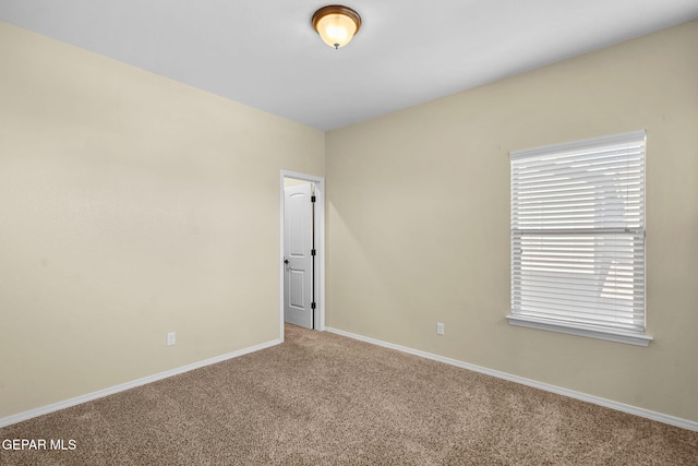 empty room with baseboards and carpet floors