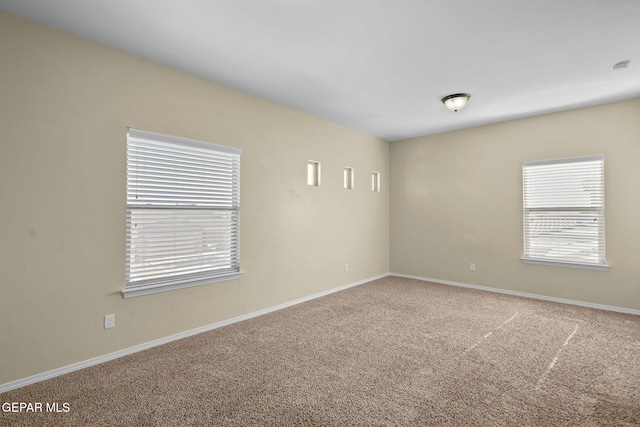 carpeted spare room with baseboards