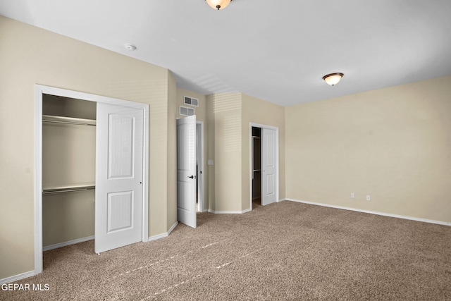 unfurnished bedroom with carpet flooring, visible vents, baseboards, and two closets