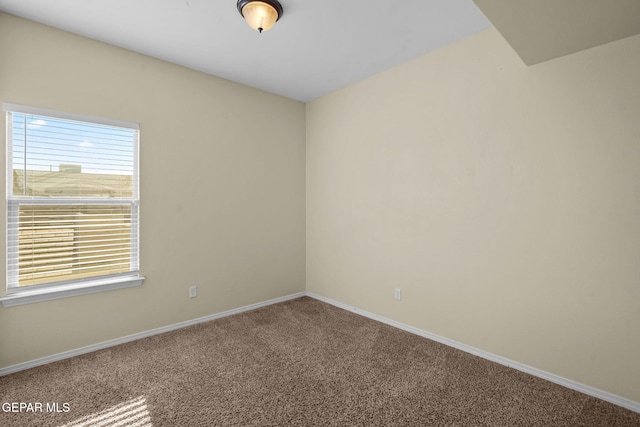 carpeted empty room with baseboards