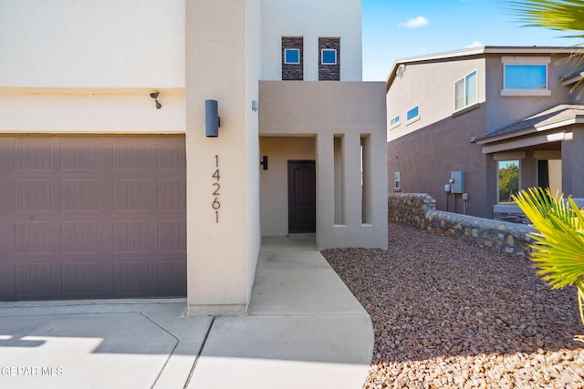 view of front of home featuring concrete driveway, an attached garage, and stucco siding