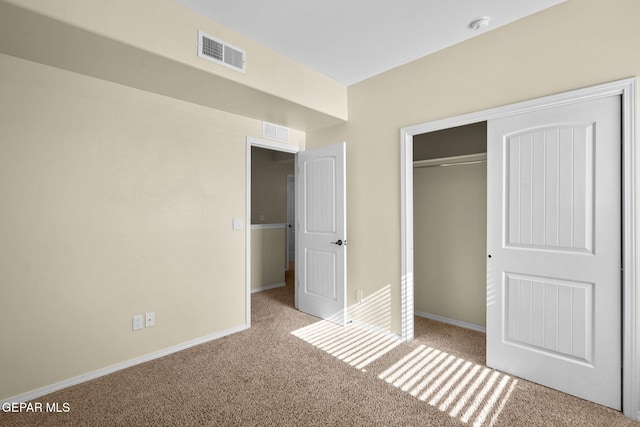 unfurnished bedroom featuring baseboards, visible vents, carpet floors, and a closet