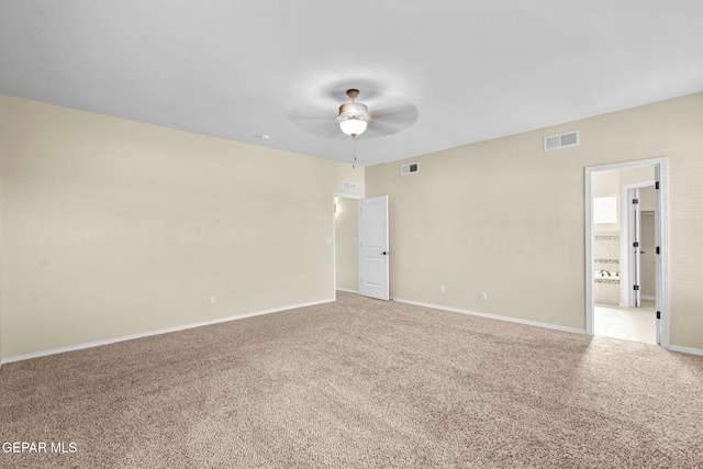 empty room with visible vents, baseboards, and light colored carpet