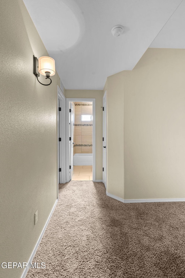 corridor with baseboards and carpet floors