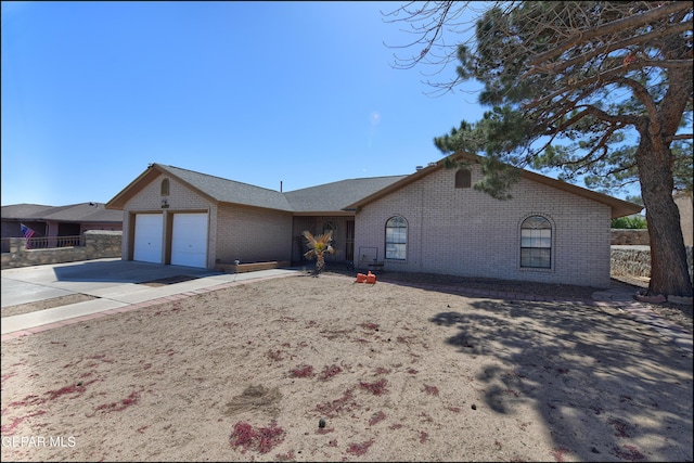 ranch-style home featuring a garage, brick siding, and driveway