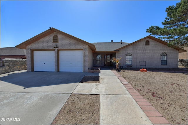 view of front of house featuring a garage, brick siding, and driveway