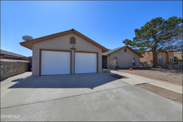 ranch-style house featuring brick siding, concrete driveway, an attached garage, and fence