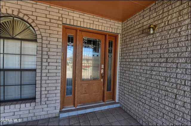 doorway to property with brick siding