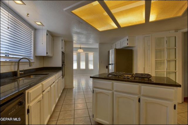 kitchen with light tile patterned floors, dishwasher, freestanding refrigerator, and a sink