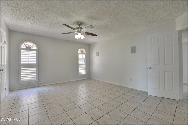 unfurnished room featuring light tile patterned floors, baseboards, a textured ceiling, and ceiling fan