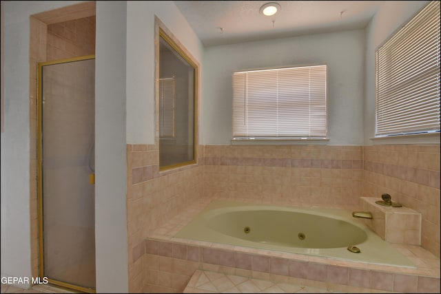 full bathroom featuring a whirlpool tub and a shower stall