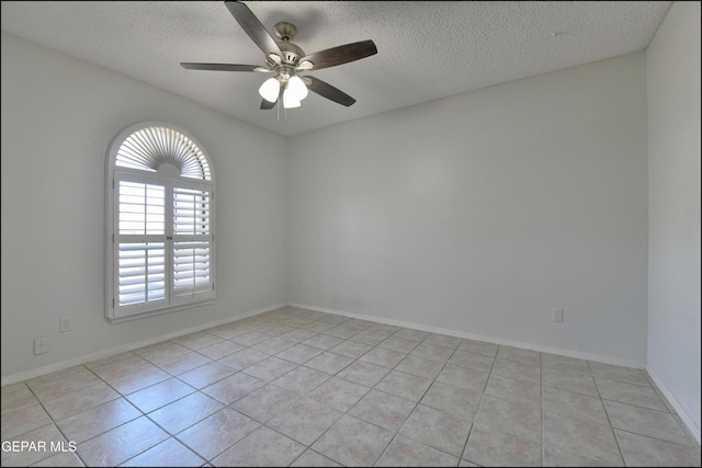 empty room featuring light tile patterned flooring, a ceiling fan, and a textured ceiling