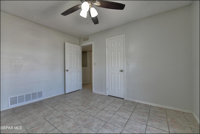 spare room with visible vents, a textured ceiling, and baseboards