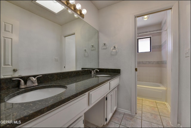 bathroom with tile patterned flooring, double vanity, baseboards, and a sink