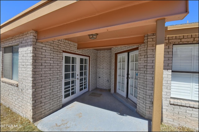 entrance to property featuring french doors and brick siding