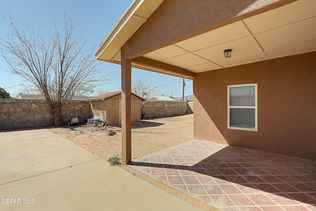 view of patio / terrace with a fenced backyard, an outdoor structure, and a shed